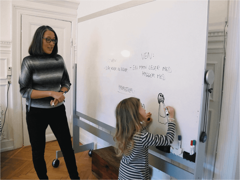 Terapi - Psykolog Mette Kyung på kontoret ved et whiteboard med et barn